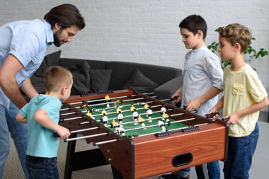 yan görünümü bir baba ve küçük oğulları oynarken futbol birlikte evde masa