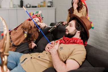 şapka ve kırmızı bandana yerli kostümleri evde oğulları ile birlikte oynayan adam