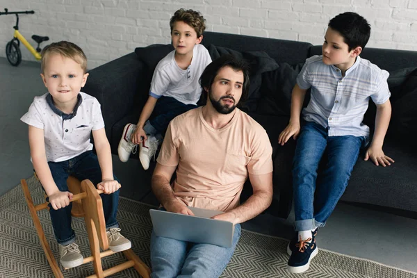 Moe Vader Met Laptop Kleine Kinderen Thuis Zitten Bank Rond — Gratis stockfoto