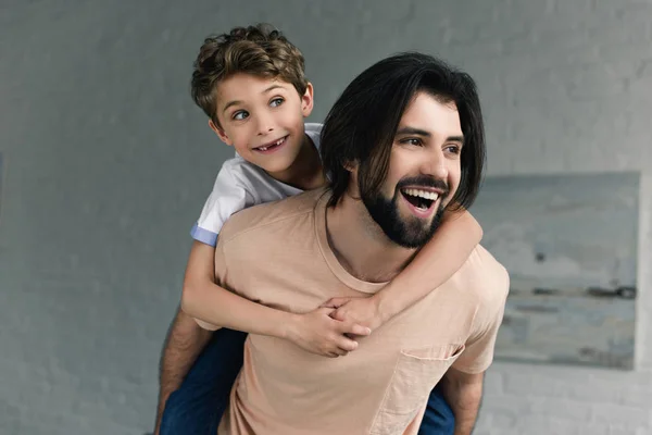 Porträt Eines Glücklichen Vaters Und Seines Kleinen Sohnes Huckepack Hause — kostenloses Stockfoto