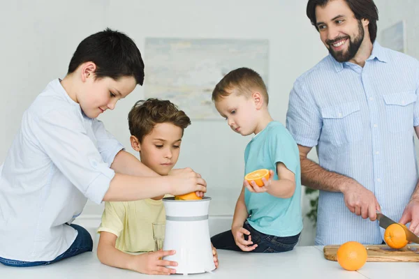 Retrato Padre Hijos Haciendo Zumo Naranja Fresco Cocina Casa — Foto de stock gratis