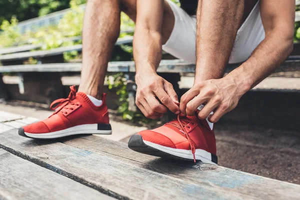 Imagen Recortada Deportista Atando Cordones Zapatos Mientras Está Sentado Banco — Foto de stock gratis