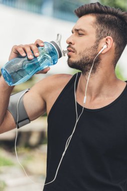 kol bandı büyük içme suyu çalışan smartphone ile kulaklıklar içinde genç sporcu 