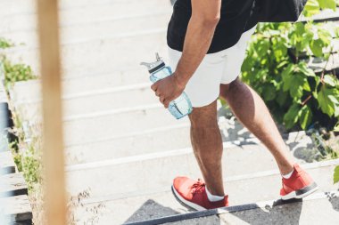 sporcu spor Bahçesi şişe suyu merdivenlerde tutan kırpılmış görüntü 