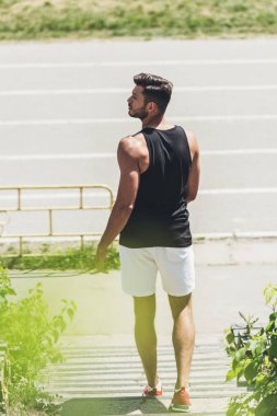 Dikiz spor Bahçesi merdiven üzerinde duran genç erkek atlet 