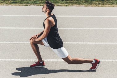 Erkek koşucu koşu parkuru, spor Bahçesi üzerinde uzanan yan görünüm 