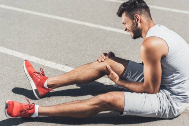 koşu parkuru katta oturan bacak yaralanma ile atletik genç atlet