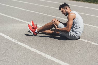koşu parkuru katta oturan bacak yaralanma ile genç atlet