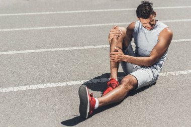 koşu parkuru katta oturan bacak yaralanma ile genç atlet acı