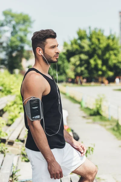 Vista Lateral Joven Deportista Serio Auriculares Con Teléfono Inteligente Caja — Foto de Stock