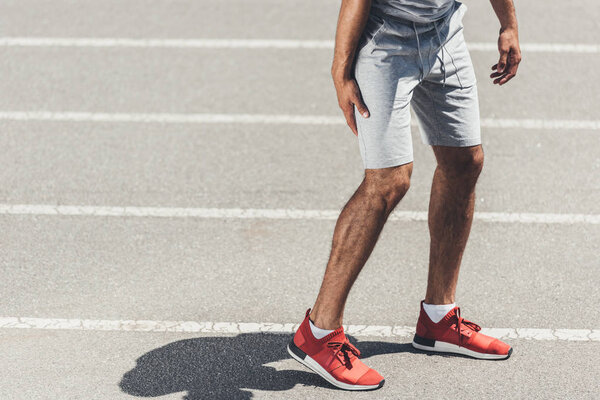 cropped shot of runner with leg injury on running track