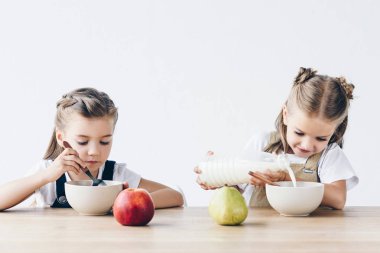 güzel kız öğrenciler üzerinde beyaz izole kahvaltı için tahıl süt ile yemek
