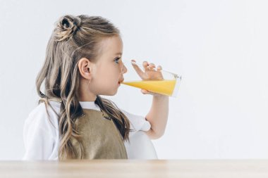 portakal suyu üzerinde beyaz izole içme ile şirin küçük kız öğrenci