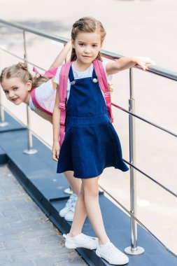 kız öğrenciler sokakta oynarken pembe sırt çantaları ile