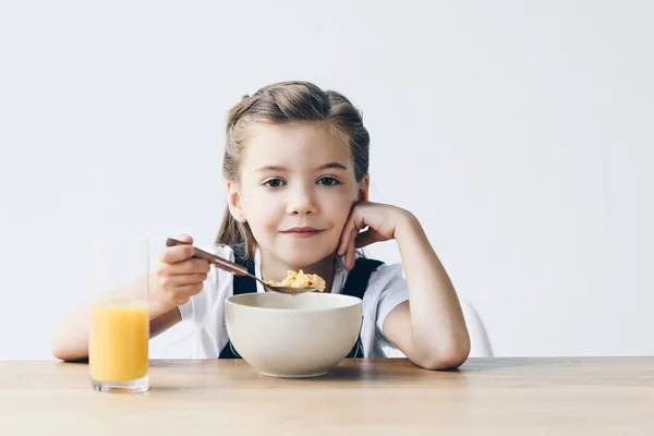 笑みを浮かべて小さな女子高生は白で隔離健康的な朝食を食べること — ストック写真