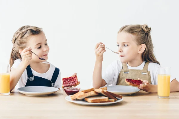 Чарівні Маленькі Сестри Їдять Тости Джемом Сніданок Ізольовані Білому — стокове фото