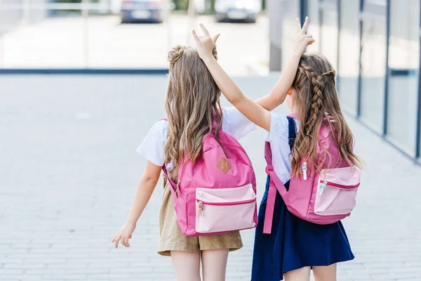 Achteraanzicht Van Weinig Schoolmeisjes Maken Van Hoorns Gebaar Aan Elkaar — Stockfoto