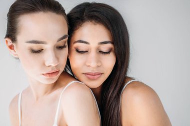 gri arka plan üzerinde izole poz iki çekici çok kültürlü bir kadın portresi 