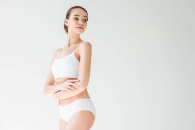gri arka plan üzerinde izole katlanmış silah ile beyaz iç çamaşırı çekici beyaz kadın 