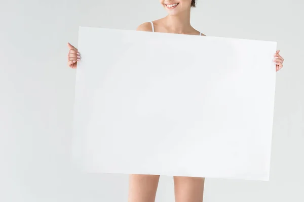 灰色の背景に分離された白紙の横断幕を持って笑顔の女性のトリミングされた画像 — ストック写真
