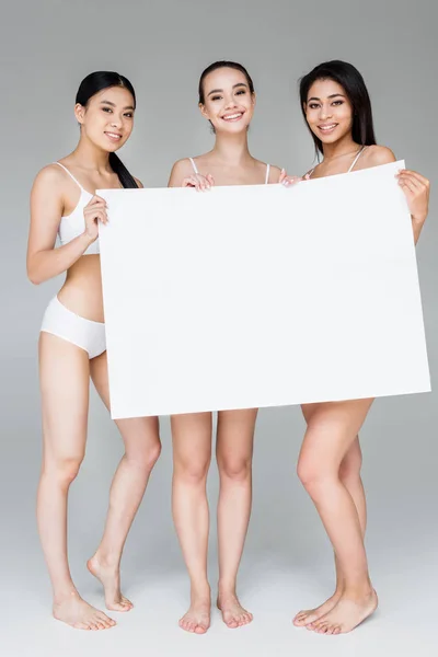 Mulheres Multiculturais Sorridentes Lingerie Segurando Banner Branco Isolado Fundo Cinza — Fotografia de Stock