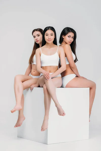 Muchachas Multiétnicas Ropa Interior Sentadas Cubo Blanco Aisladas Gris — Foto de Stock