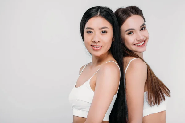 Atractivas Chicas Sonrientes Multiétnicas Sujetadores Blancos Mirando Cámara Aisladas Gris — Foto de Stock