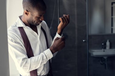 yakışıklı genç iş adamı beyaz gömlek kol düğmeleri, banyo kadar düğmelerini