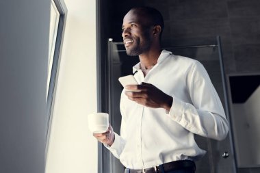mutlu genç işadamı kahve molası sırasında smartphone kullanarak beyaz gömlekli alttan görünüm