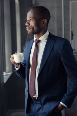 yakışıklı genç işadamı kahve uzağa bakarak Kupası ile