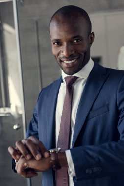 close-up portrait of handsome young businessman in stylish suit and wristwatch looking at camera clipart