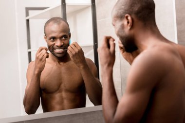 banyo aynada bakarken Temizleme diş diş ipi ile mutlu genç adam