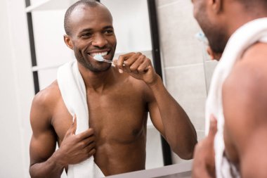 sabah, banyo aynada bakarken diş fırçalama yakışıklı genç