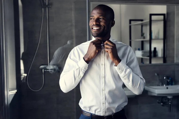 Sorridente Empresário Abotoando Sua Camisa Branca Banheiro Olhando Para Longe — Fotografia de Stock