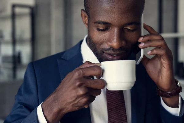 Крупный План Красивого Молодого Бизнесмена Чашкой Кофе Разговаривающего Телефону — стоковое фото