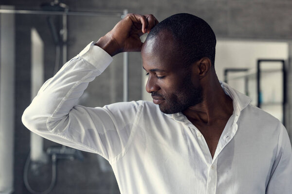 handsome young man in white shirt looking at his wet armpits