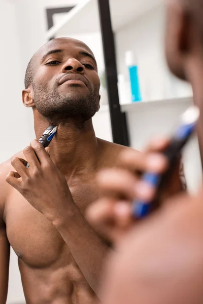 Jongeman Scheren Baard Met Elektrisch Scheerapparaat Tijdens Het Kijken Van — Stockfoto