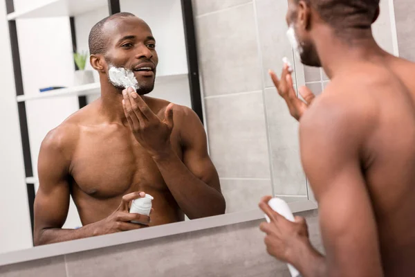 Jovem Atraente Aplicando Gel Barbear Enquanto Olha Para Espelho Banheiro — Fotografia de Stock