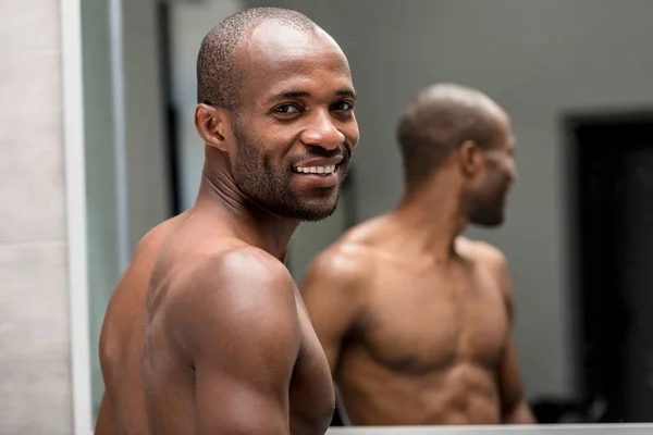 浴室で立ったままカメラに微笑んでハンサムな上半身裸のアフリカ系アメリカ人アメリカ人 — ストック写真