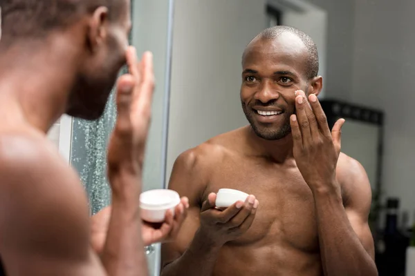 Ritagliato Colpo Sorridente Giovane Afroamericano Uomo Applicare Crema Viso Guardando — Foto Stock