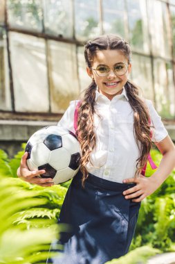 Bahçe kameraya bakarak futbol topu ile güzel kız öğrenci