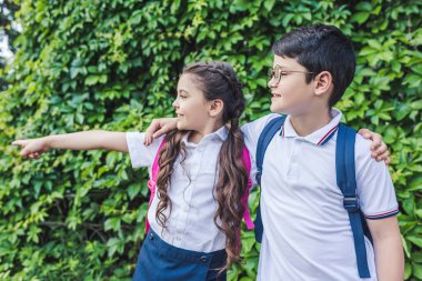 Okul Asma duvarın önünde duran ve tarafından bakarım sırt çantaları ile