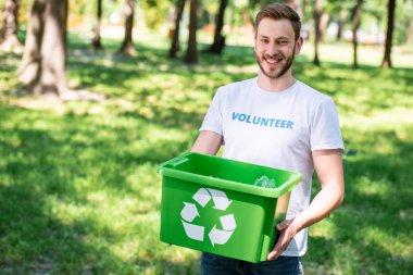 smiling volunteer holding recycling box with plastic trash clipart