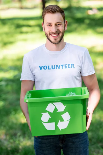 Sorridente Voluntário Masculino Segurando Caixa Reciclagem Com Lixo Parque — Fotografia de Stock