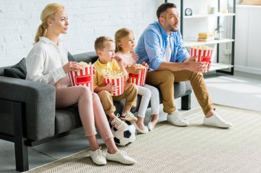 koltukta oturan, patlamış mısır yemek ve uzakta ev arıyorum futbol topu ile aile