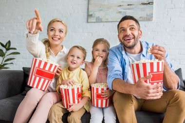 patlamış mısır yemek ve birlikte evde tv izlerken neşeli aile