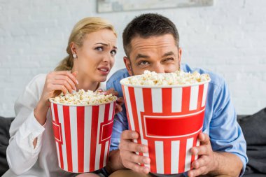 duygusal çift evde tv izlerken patlamış mısır kutuları tutarak