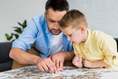 Baba ve oğul parçalı bulmaca ile birlikte evde oynarken odaklı 