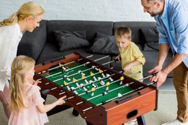 birlikte evde masa futbolu oynayan iki çocuklu mutlu aile yüksek açılı görünüş 