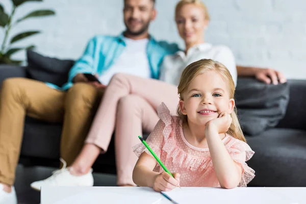 Adorable Niño Dibujo Con Lápiz Sonriendo Cámara Mientras Los Padres — Foto de Stock